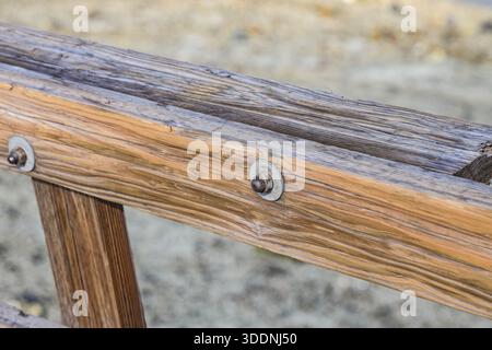 Supports métalliques boulons, écrous, filetés sur les poutres de la clôture en bois. Banque D'Images