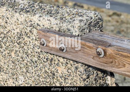 Supports métalliques boulons, écrous, filetés sur les poutres de la clôture en bois. Banque D'Images