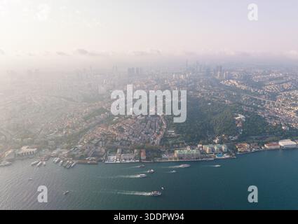 Istanbul, Turquie. Vue aérienne captivante d'une ville qui s'étend le long d'un front de mer, avec de la brume enveloppant l'horizon. La scène met en valeur un beau bl Banque D'Images