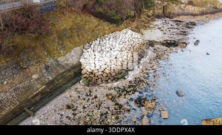 Vue aérienne des rochers installés comme défense contre l'érosion côtière le long du rivage à Llandudno dans le nord du pays de Galles Banque D'Images