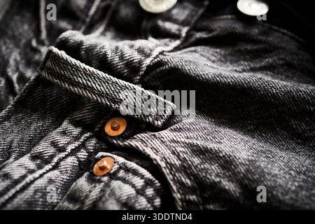 Gros plan d'un Jean en denim foncé mettant l'accent sur la ceinture, la boucle de ceinture et les boutons de rivet en métal Banque D'Images