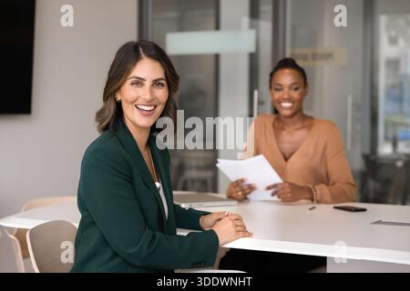 Femme candidate heureuse assise à la table de réunion avec l'intervieweur Banque D'Images