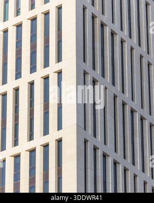 Doha, Qatar - 21 février 2025 : vue sur la symétrie architecturale d'un bâtiment moderne, avec ses motifs rythmiques de fenêtres créant un captivant Banque D'Images