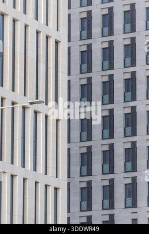 Doha, Qatar - 21 février 2025 : vue sur l'architecture moderne et dure, avec des motifs répétitifs de fenêtres créant un paysage urbain rythmé, le refle de pierre pâle Banque D'Images