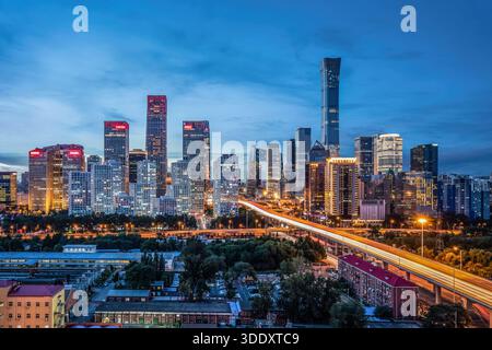 Horizon du quartier central des affaires de Pékin au crépuscule, gratte-ciel modernes et trafic routier brillant dans le quartier des affaires de Guomao, en Chine. Banque D'Images