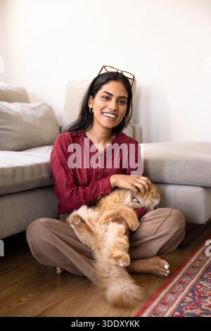 Femme heureuse tenant adorable chat de gingembre fourré dans les bras Banque D'Images