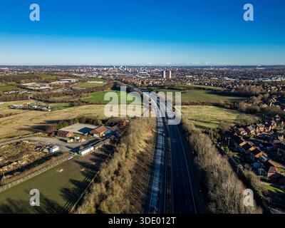 Vue aérienne sur l'autoroute M621 en direction du centre-ville de Leeds, avec des logements de banlieue et des espaces verts dans le West Yorkshire, Royaume-Uni Banque D'Images