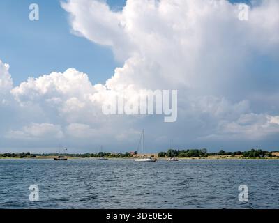Voiliers ancrés dans la baie abritée près de Langør avec la côte de Samsø en arrière-plan, Danemark Banque D'Images