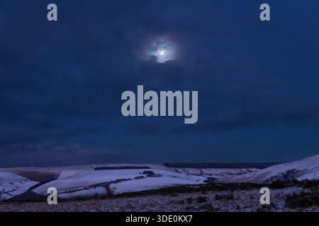 La Lune du loup de début janvier brille sur les collines enneigées de la forêt de Radnor au-dessus de Llandegley (près de Builth Wells, Powys, centre du pays de Galles, Royaume-Uni) Banque D'Images
