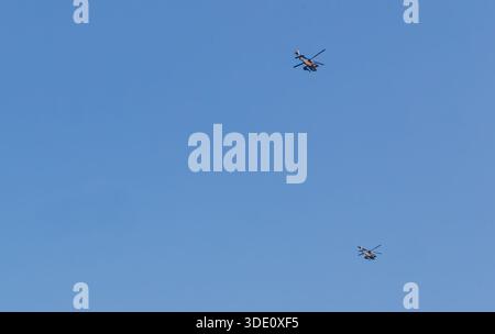 Plan horizontal grand angle à hauteur des yeux montrant deux avions de couleur brun en vol contre un ciel bleu vaste et sans nuages, mettant l'accent sur l'échelle de l'aviation Banque D'Images