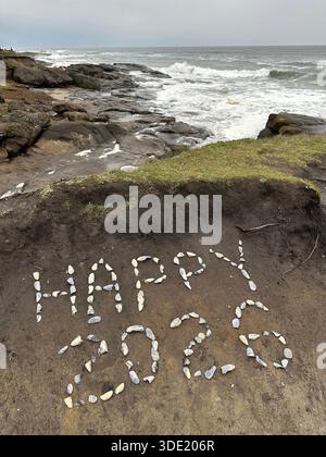 Salutation du nouvel an « Happy 2026 » écrite dans des coquillages sur la côte à Yachats, Oregon. Banque D'Images