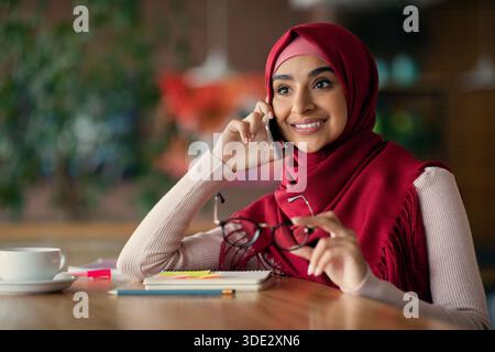 Jeune femme d'affaires du Moyen-Orient ayant une conversation téléphonique Banque D'Images