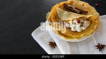 Crêpes fines avec crème fouettée et épices sur la serviette vue de dessus Banque D'Images
