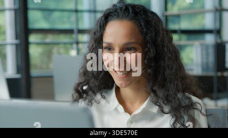 Positive hispanique femme d'affaires parlant appel vidéo dans le bureau souriant femme d'affaires joyeuse femme fille parler conférence chat virtuel ordinateur Banque D'Images