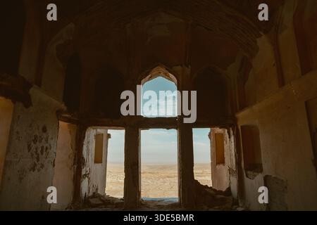 Vue intérieure de l'intérieur du manoir historique Abbas Abad, Natanz, Ispahan, qui offre une vue vaste et aride sur le désert à travers des ouvertures voûtées. Banque D'Images