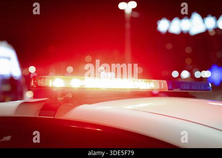 Vue rapprochée des feux clignotants de la sirène de voiture de police la nuit. Feux de police bleus et rouges Banque D'Images