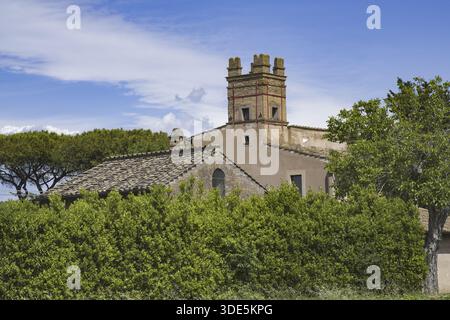 DSC 4395 ancienne tour médiévale crénelée d'une ferme rurale entourée d'une végétation épaisse et d'arbres sous un ciel bleu, Italie. Banque D'Images