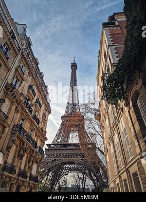 Vue panoramique sur la Tour Eiffel encadrée par d'élégants bâtiments résidentiels parisiens. Le monument complexe en treillis de fer dominant le Haussma classique Banque D'Images