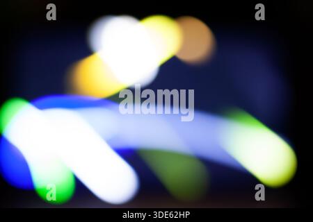 Traces de lumière abstraites : couleurs vives et flou de mouvement en arrière-plan sombre Banque D'Images