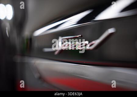 Un gros plan montre le script Speed chromé sur une Bentley Bentayga Speed, avec des lumières de studio douces, une faible profondeur de champ, une peinture noire brillante et un Banque D'Images