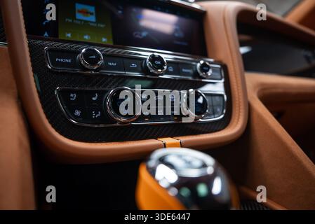 La vue intérieure en gros plan montre des garnitures en fibre de carbone, du cuir beige, des cadrans chromés moletés, une climatisation à deux zones réglée sur 22 C, des boutons Nav et OK du téléphone et un cristal Banque D'Images