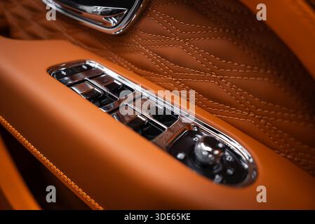 Gros plan montrant des coutures diamantées, un appareillage de commutation chromé et un sélecteur de miroir rotatif moleté. Les boutons biseautés réfléchissent la lumière à l'intérieur avec une faible profondeur de Banque D'Images