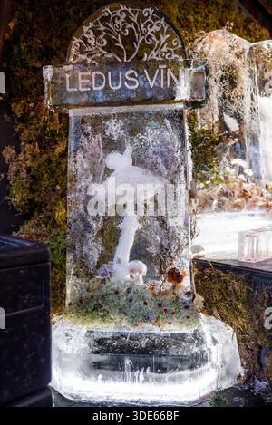 Une sculpture de glace sculptée avec un champignon sous une arche LEDUS VINA se tient sur un stand festif à Riga, Lettonie, décoré avec des éléments moussues et un décor givré, brillant Banque D'Images