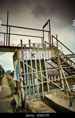 Installation abandonnée et couverte de graffitis en bordure de quai sur les rives de la rivière Wyre à Fleetwood, Royaume-Uni Banque D'Images