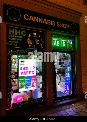 Brno, République tchèque - 29 novembre 2025 : vue nocturne d'un magasin de cannabis exposant des produits HHC et vape avec néons. Banque D'Images
