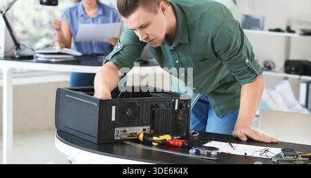 Technicien électronique répare l'ordinateur dans le centre d'entretien Banque D'Images
