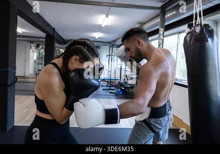 Deux boxeurs sparring dans un gymnase, pratiquant la défense et les techniques de frappe Banque D'Images