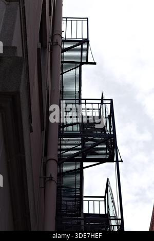 L'évacuation d'incendie en métal grimpe sur le côté d'un immeuble urbain Banque D'Images