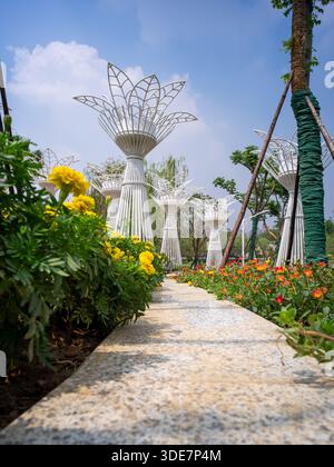 WUHAN, CHINE - 17 SEPTEMBRE 2015 : sculptures créatives en métal blanc en forme de fleurs debout parmi des soucis jaunes en fleurs dans un jardin à Wuhan G. Banque D'Images