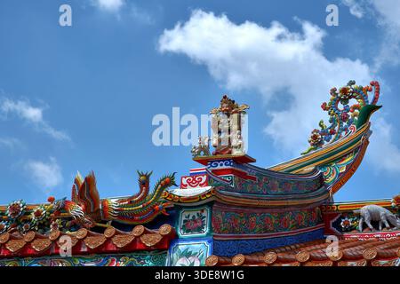 Une proue dragon-boat spectaculaire avec des vagues de curling décore le bord d'un toit de temple chinois dans le cimetière Teochew de Bangkok. Banque D'Images