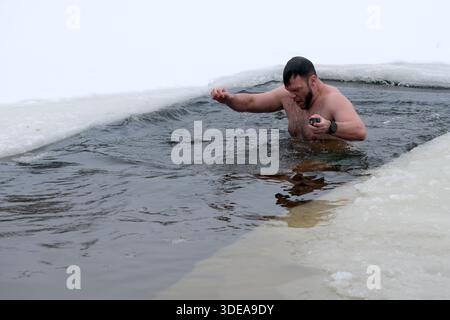 Un homme prend un bain audacieux dans l'eau froide au milieu d'un environnement glacé, faisant preuve de bravoure. Kiev, Ukraine, 6 janvier 2026. Baignade de trous de glace sur l'Épiphanie. Banque D'Images