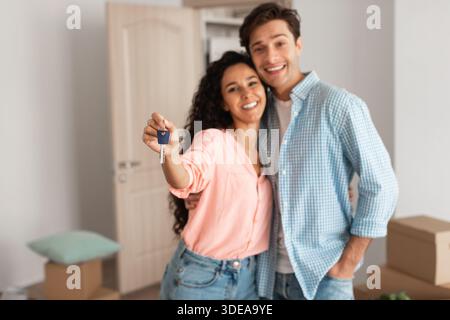 Happy couple montre Keys le jour du déménagement dans leur nouvel appartement Banque D'Images
