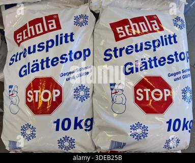 Kiel, Allemagne - 22. Décembre 2025 : sacs de Streusplitt Glättestop avec panneau d'arrêt et iconographie bonhomme de neige Banque D'Images