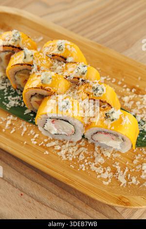 Les rouleaux de sushi sont disposés soigneusement sur un plateau en bois, mettant en valeur des couleurs et des textures vibrantes. Ce plat met en valeur un mélange d'ingrédients qui reflètent Ja Banque D'Images