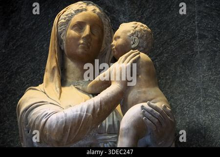 Gros plan d'une statue de marbre représentant la Sainte mère Marie tenant l'enfant Jésus dans ses bras à l'intérieur d'une église catholique historique à Rome, en Italie Banque D'Images