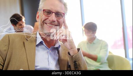 Homme souriant portant un blazer Havane, chemise à carreaux bleus, lunettes rouges dans le salon du bureau, superposition de forme d'onde Banque D'Images