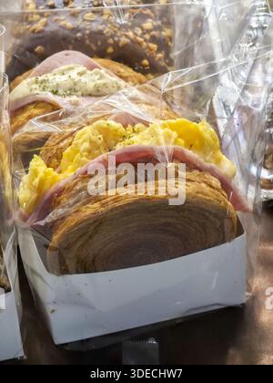 Délicieux sandwich sandwich au jambon emballé sac en plastique transparent et boîte en papier prêt pour le repas à emporter, montrant une texture tentante de pâte feuilletée et jaune, par exemple Banque D'Images