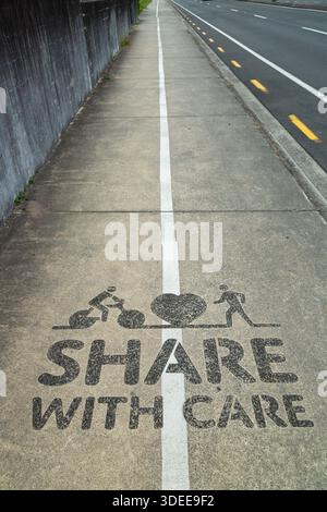 Piste cyclable et sentier partagé, signe avec 'care', Rotorua, île du Nord, Nouvelle-Zélande Banque D'Images