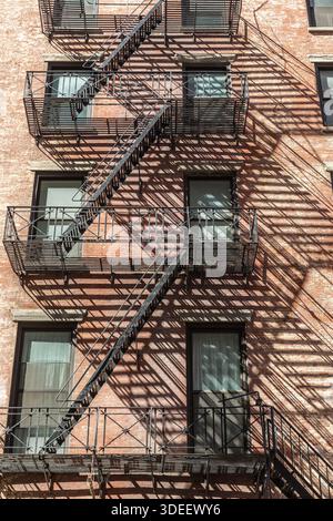 Les échappées de feu et leurs ombres projetées sur la façade du bâtiment auquel elles sont rattachées. Banque D'Images