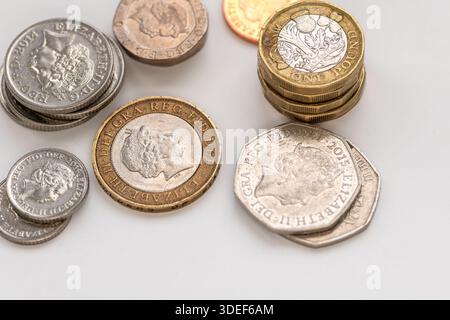 Un gros plan de piles de différentes pièces de monnaie sterling en livre sterling isolées sur blanc. Banque D'Images