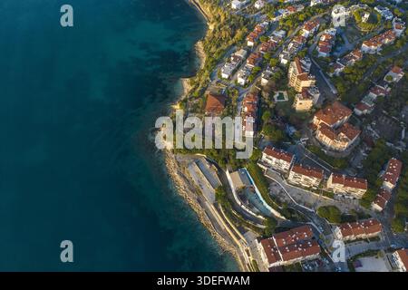 Vue aérienne de la côte avec des toits en terre cuite descendant la colline vers la mer Azur, Kusadasi, Aydin, Turkiye. Banque D'Images