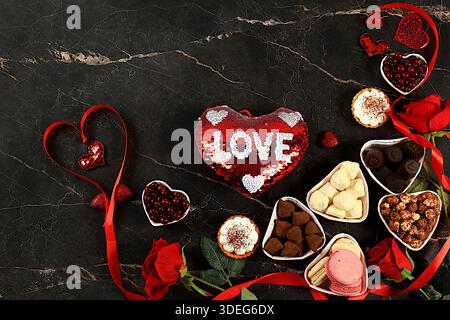 Nourriture pour la Saint-Valentin ou la Fête des femmes, bonbons au chocolat en forme de coeur gourmand, canneberge au sucre, meringue et fleurs de rose, carte de voeux, Adversin Banque D'Images