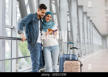 Portrait d'un couple de voyageurs islamiques heureux debout à l'aéroport Banque D'Images