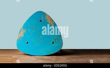 Objet en bois abstrait, fond futuriste moderne. Objet bleu triangle, isolé sur table en bois. Fragment d'une chaise déchirée, peinte et minable Banque D'Images
