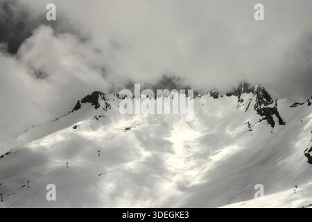 Majestueux sommets rocheux de la montagne Zugspitze émergeant d'un épais brouillard et de la neige en hiver. Banque D'Images
