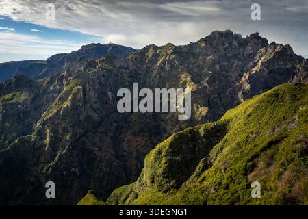 Vue panoramique sur les crêtes de montagne accidentées et le sommet lointain du Pico do Arieiro vu du sentier de randonnée menant au Pico Ruivo sur l'île de Madère Banque D'Images